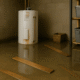 A basement flooded with water damage from a burst water heater tank, showing soaked building materials and personal belongings scattered around.A basement flooded with water damage from a burst water heater tank, showing soaked building materials and personal belongings scattered around.