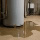 Puddles around a water heater indicating potential leaks.
