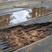 A wooden deck showing signs of moisture rot.